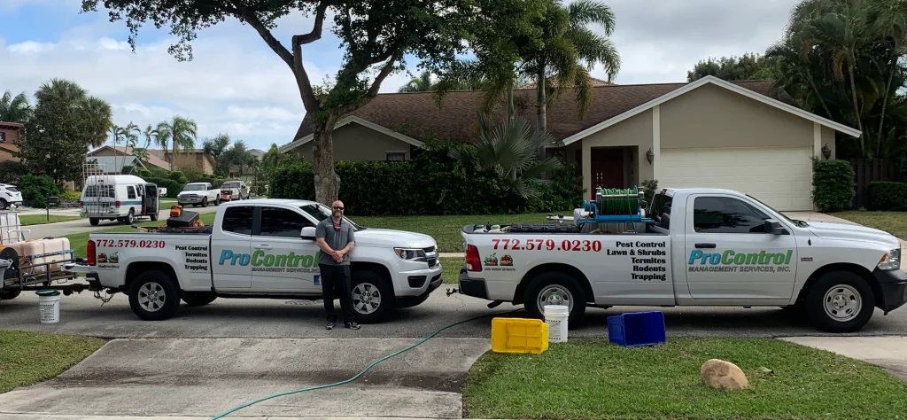 Two ProControl pest control trucks are parked in a driveway, with a person standing between them outside.