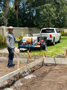 Pest control worker treating an outdoor residential area in St. Lucie County, Florida to help prevent insects and pests