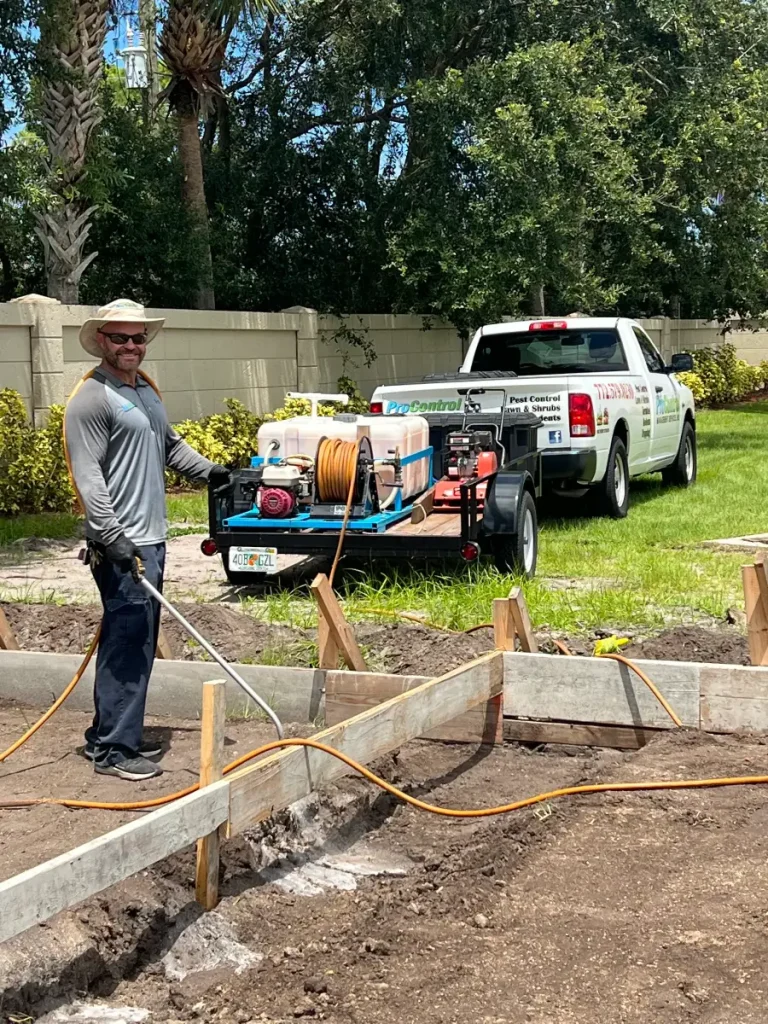 Pest control worker treating an outdoor residential area in St. Lucie County, Florida to help prevent insects and pests